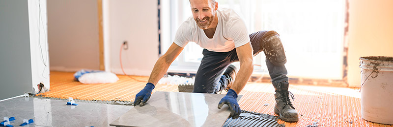 Male entrepreneur working on applying a new floor to a recent residential home purchase.
